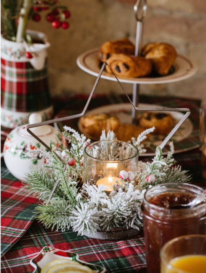 Centrotavola con stella o albero decorato con pino innevato, pignette e bacche